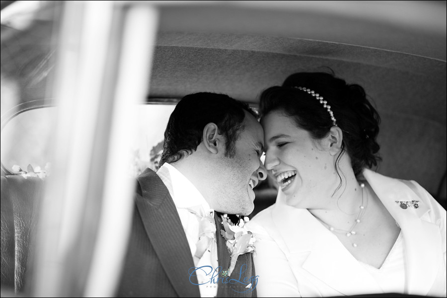 Bride and groom laughing in car after wedding ceremony