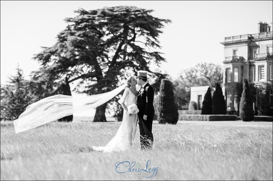 Black and white image of bride and groom standing outside Hedsor House