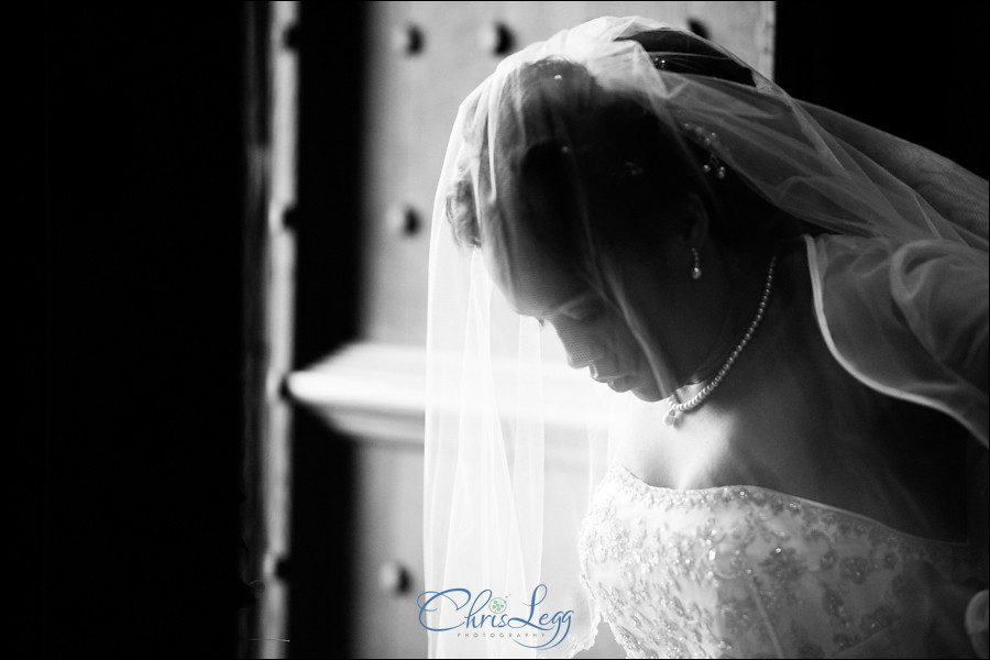 Black and white image of a Bride waiting in the doorway of Sherborne Abbey