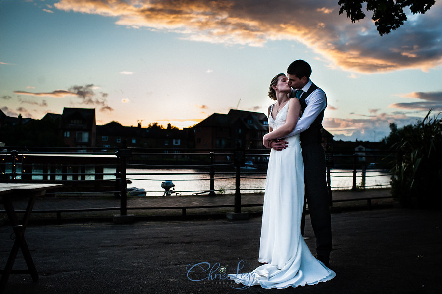 Bride and groom stand together as the sun sets in Windsor