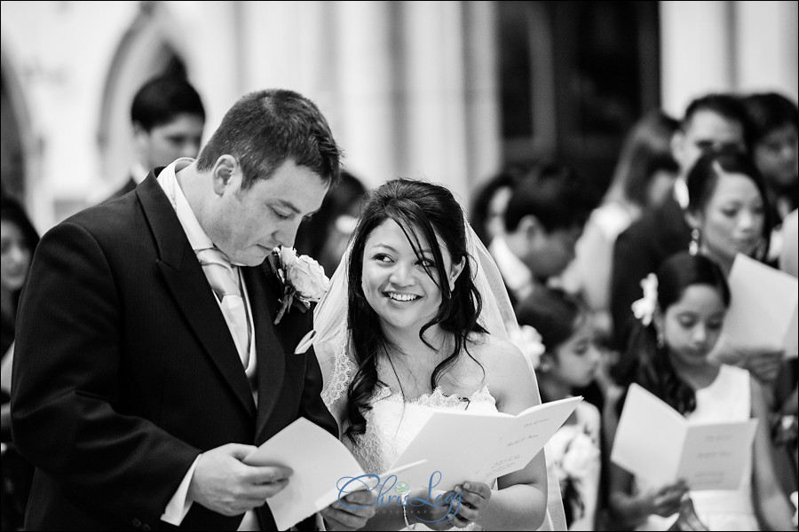 Black and white image of a bride and groom during the ceremony at Sacred Heart in Wimbledon